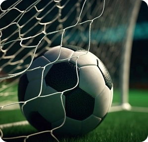 Gros plan d'un ballon de football qui bouge au fond des filets d'un but sur la pelouse verte