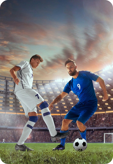 Deux joueurs de football, l'un en blanc et l'autre en bleu, se disputant le ballon sur le terrain d'un grand stade sous un ciel de coucher de soleil.